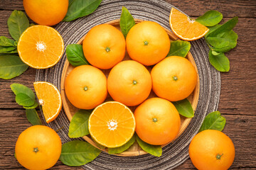 Fresh Orange fruit on wooden basket on wooden background, Japanese Ehime Orange with slices on...