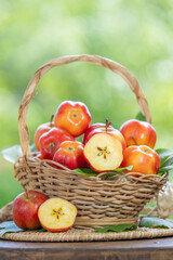 Sweet red star apple in wooden bowl on wooden table in garden, Star Apple with slices on blurred...