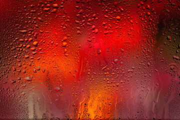 Drops of rain on the window. Water drops on glass. Abstract background. Multi-colored spots. Texture of drops. Selective focus