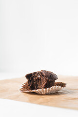 Homemade half eaten dark chocolate muffins on a white tray, chocolate muffins with copy space and white background