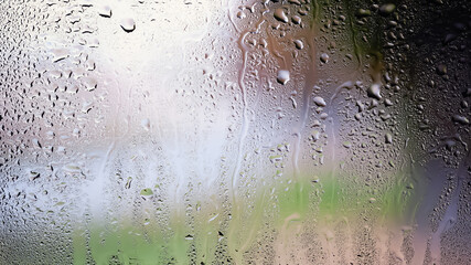 Raindrops on the window. Drops of water on the glass. Abstract background. Urban landscape. Texture of drops