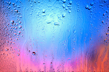Drops of rain on the window. Drops of water on the glass. Abstract background. Multi-colored spots. Texture of drops