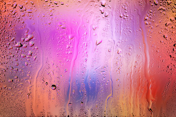Drops of rain on the window. Water drops on glass. Abstract background. Colorful spots. Texture of drops