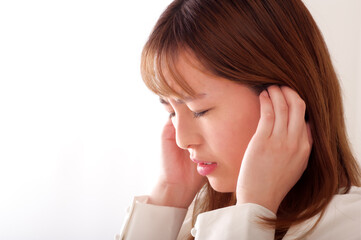 耳を塞ぐ若い女性