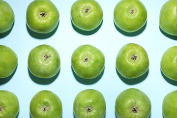 Ripe green apples on light blue background, flat lay