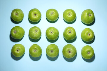 Ripe green apples on light blue background, flat lay