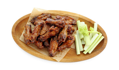 Wooden plate with delicious chicken wings and cut celery stalks isolated on white, top view