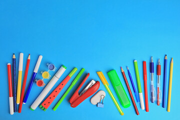 Flat lay composition with different school stationery on light blue background, space for text....