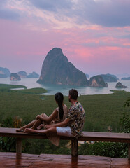 A couple of men and woman watching the sunrise at Sametnangshe viewpoint Phangnga Bay with mangrove...