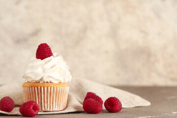 Tasty raspberry cupcake on table