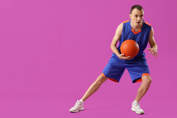 Young basketball player on purple background