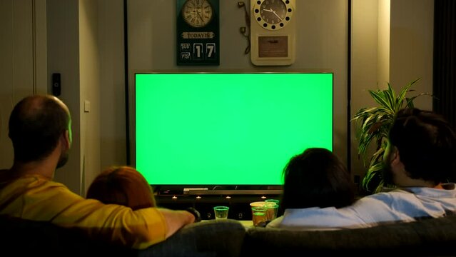 Two couples watching a movie together on the green screen