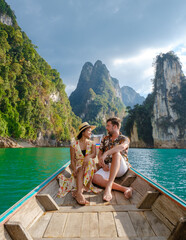 A couple of men and women in front of a longtail boat in Khao Sok Thailand, Scenic mountains on the...