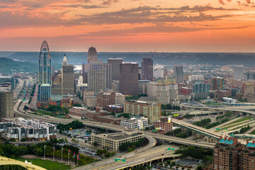 Aerial view of downtown district of Cincinnati city in Ohio, USA at sunset. Brightly illuminated high skyscraper buildings in modern American midtown