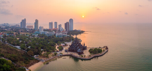 The Sanctuary of Truth wooden temple in Pattaya Thailand at sunset seen from the beach by the...
