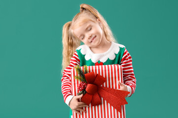Dreaming little elf with Christmas gift on green background