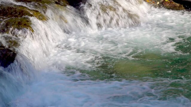 A stream flows over a natural obstacle. River Passer in Meran - Merano, South Tyrol, Italy.