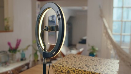 Ring light on stand with phone holder ready for filming social media vlog in the living room with box on the table. Close-up shot