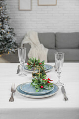 Beautiful table setting with mistletoe for Christmas dinner in living room