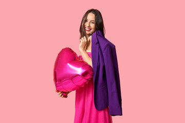 Happy young woman with heart shaped air balloon on pink background. Valentine's Day celebration
