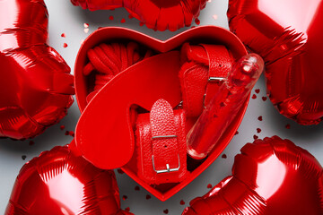 Gift box with different sex toys and heart shaped air balloons on grey background. Valentine's Day celebration - obrazy, fototapety, plakaty