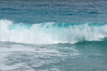 白砂の海岸に打ち寄せる透明度の高い波