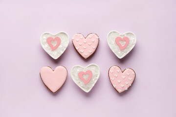 Fototapeta premium Heart shaped sweet cookies and bowls with snow on lilac background. Valentine's day celebration