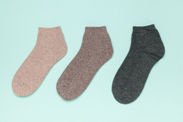 Three short multi-colored socks on a blue background.