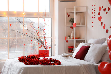 Interior of light bedroom decorated with hearts for Valentine's Day celebration