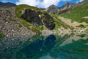 View of the Dukka lake "Rybka" on the Malaya Dukka River on the slopes of the Arkasar ridge in the North Caucasus on a sunny summer day, Arkhyz, Karachay-Cherkessia, Russia © Ula Ulachka