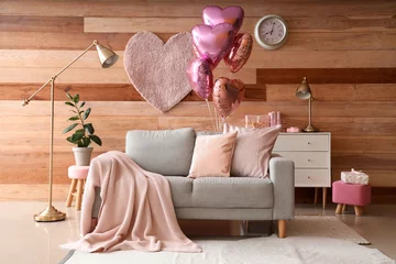 Fotobehang Interior of festive living room with grey sofa and heart-shaped balloons. Valentine's Day celebration © Pixel-Shot