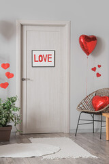 Interior of festive room with hearts and word LOVE hanging on door. Valentine's Day celebration