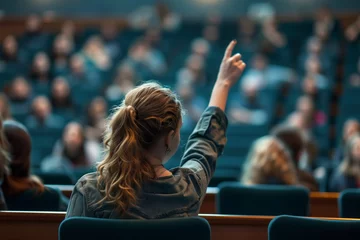 Foto op Aluminium Young female Raises a Question in a Crowded Auditorium © Peeradontax