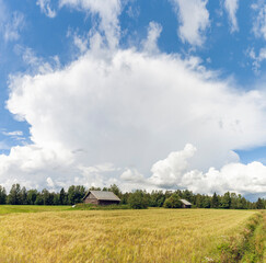Landscape with a barn and a Cumulonimbus cloud on a warm summer day