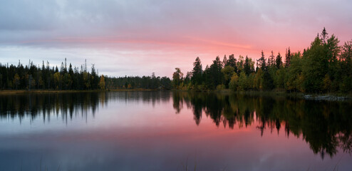 Fototapeta premium Red evening clouds over a small wilderness lake in Northern Finland