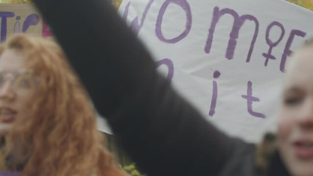 Group of initiative young women with empowerment posters and banners fighting for gender equality during demonstration protest on street