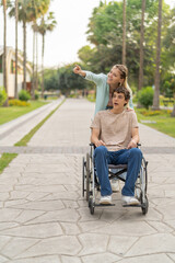 Woman showing something to a friend sitting on wheelchair