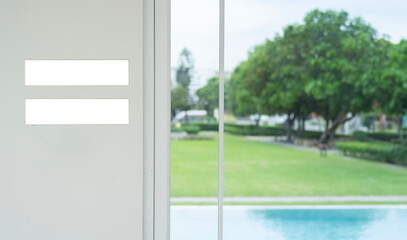 Small blank sign board stand on white wall background near swimming pool with copy space