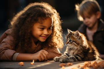 Little happy multinational children are playing with a cat in the kindergarten