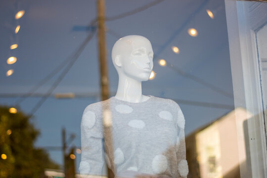 Mannequin in Shop Storefront Window Shopping New Orleans Wearing Grey Spotted Sweater with Reflection and Bokeh