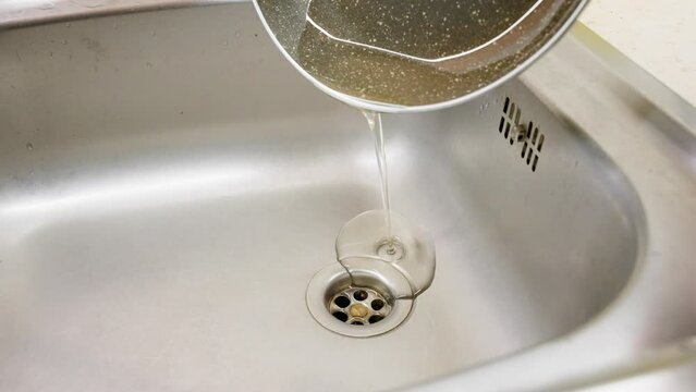 Macro shot of Pouring down used oil on the drains. Collection of used household edible oil.
