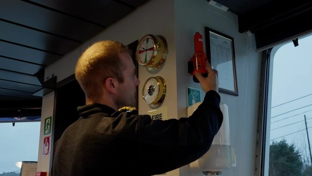 Ships Captain testing emergency radar transponder SART, wheelhouse
