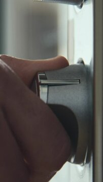 Vertical side stab macro closeup of hand turning on oven using power control in kitchen
