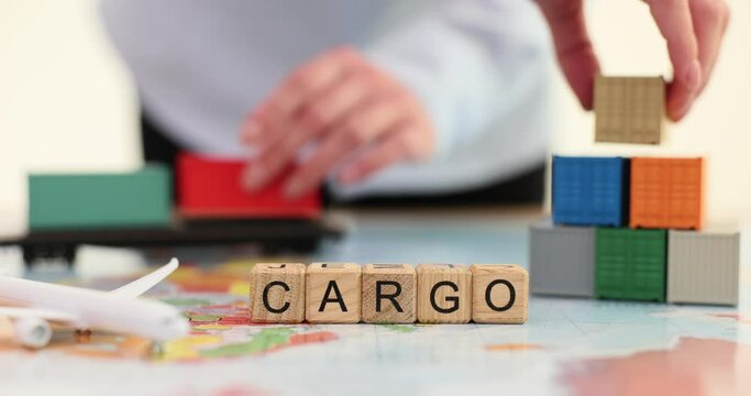 Word cargo on wooden cubes near containers on train and plane closeup 4k movie slow motion