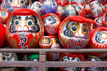 A close up shot of traditional Japanese daruma dolls piled up at Shorinzan Daruma-ji Temple in...