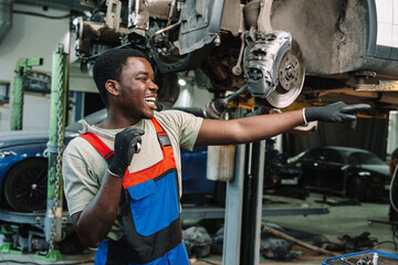 African man mechanic in uniform at the car repair station, portrait