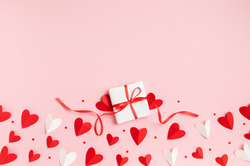 Gift or present box for Saint Valentine or Mother day decorated with paper red hearts top view. Flat lay festive greeting card.