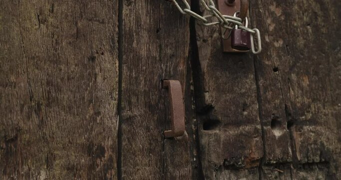 Zoom in on an old rusty metal handle on an old oak gate