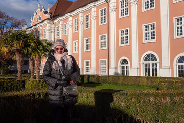 Portrait of a mature woman in a jacket, hat and sunglasses in the park