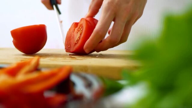 잘익은 빨간 색 싱싱한 토마토를 줄기에서 떼어낸뒤 칼로 자르는 